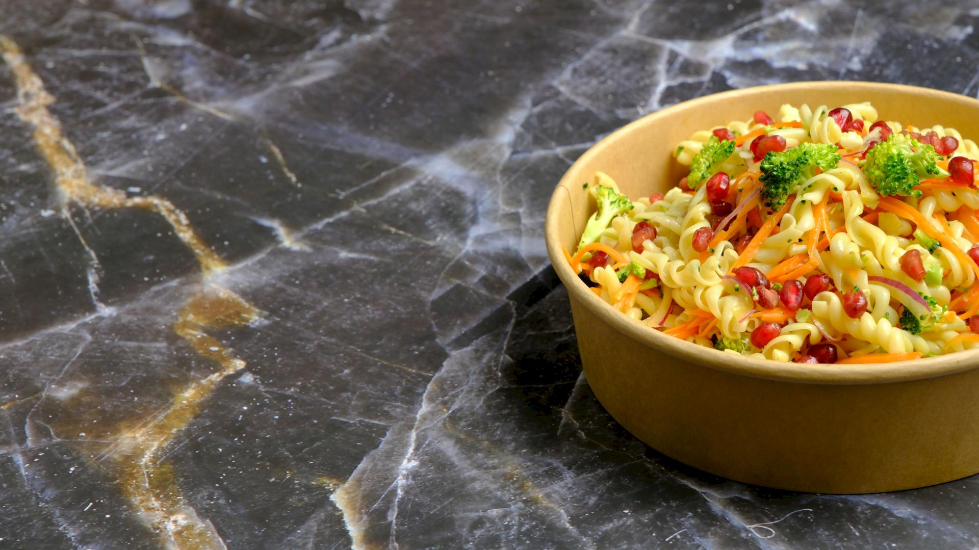 Vier wei&szlig;e Schalen mit verschiedenen Reissorten auf einem rot-beigen Tuch.